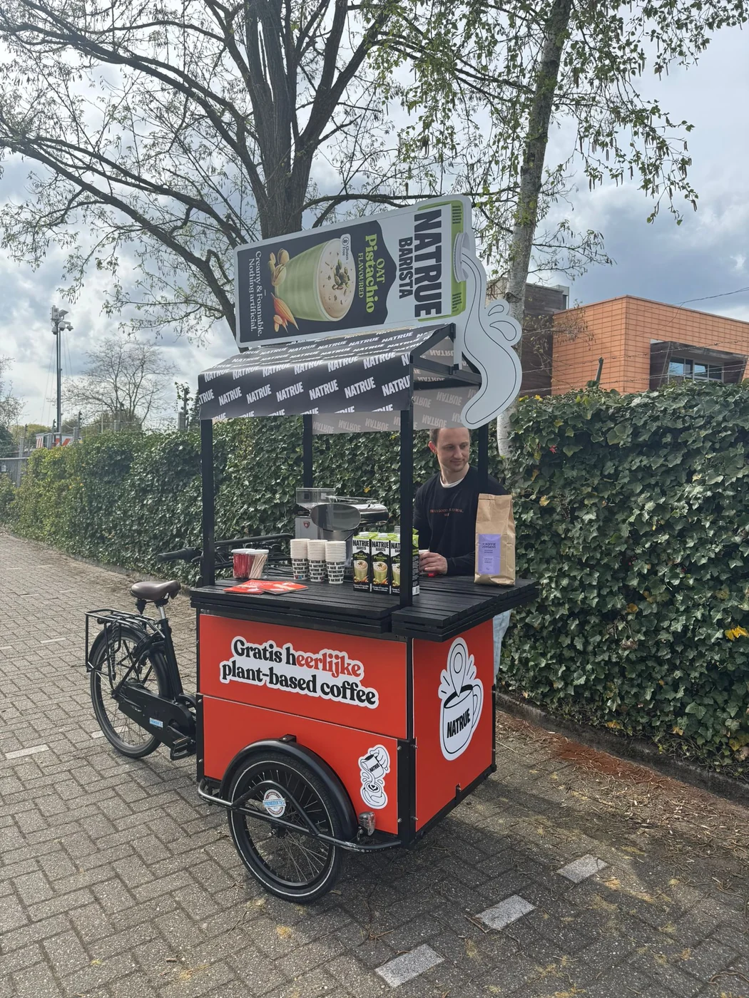 Natrue plant-based coffee — promobakfiets met full colour panelen, op model van de bakfiets gesneden